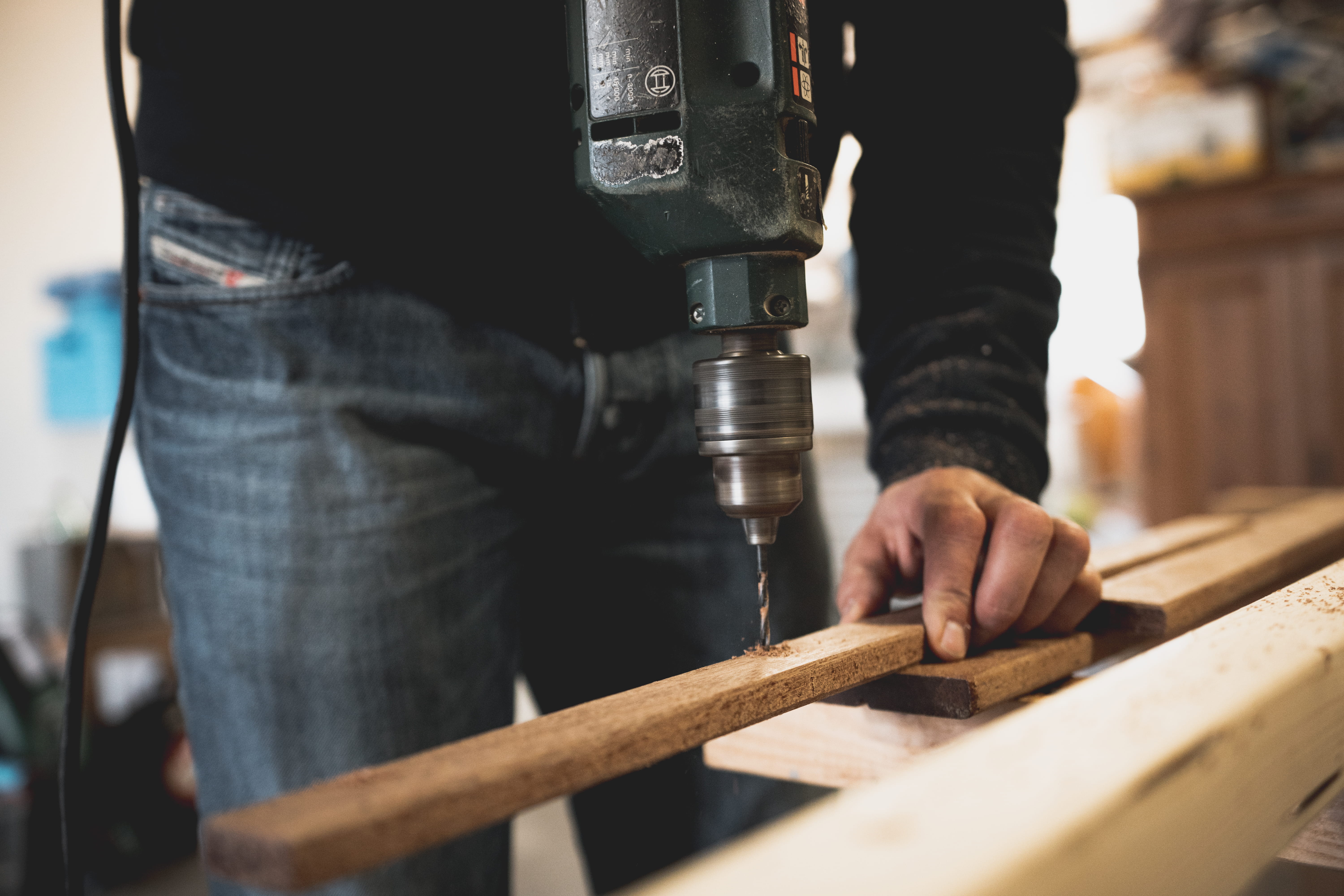 Schreiner bohrt eine Holzleiste am Werkstück